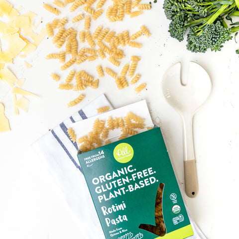 Overhead view of Rotini Pasta spilling out of the box with fresh ingredients nearby