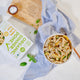 Overhead view of Creamy Garlic Pasta in a bowl with product packaging and fresh ingredients surrounding.
