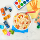 overhead view of kids creamy mac with toys and crafts nearby