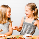 Two young girls enjoying pasta together